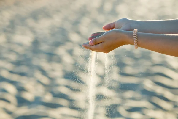 Güzel kız sahilde kum dağılım eller. Kavram - zaman doluyor hiçbir şey sonsuza kadar sürmez. Metin için yer kopyalayın