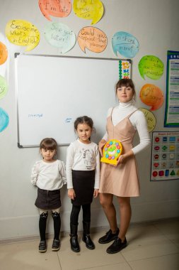 Küçük öğrenci tahta dersi ile tanışır. Öğretmen ev ödevini kontrol eder..