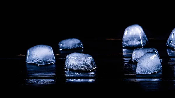Niebieskie kostki lodu na czarnym tle. Zdjęcie reklamowe — Zdjęcie stockowe