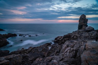 La Torche alacakaranlıkta uzun pozlama fotoğraf kayalar ve deniz