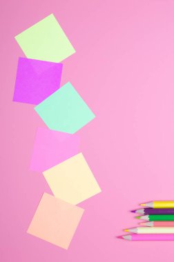 renkli kalemler ve kırmızı bir arka plan üzerinde renkli kağıt