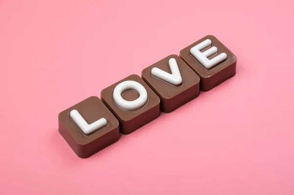 在彩色背景上刻有巧克力的爱情 — 图库照片