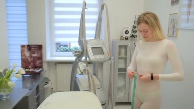 Klinikte Lipomassage sonrası kadın ve adam. Çocuk onu ile Lipomassage sonra yeşil şerit ile kıza bel ölçme
