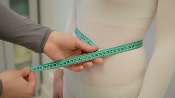 Mannetjes handen zijn het meten van de magere meisjes taille met groene snaar. Geen gezicht. Een jongen meten taille aan zijn meisje met groen lint — Stockvideo