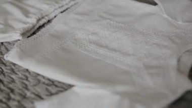 Yatakta yeni doğmuş bir çocuk için bebek kıyafetlerinin yakın plan çekimi.