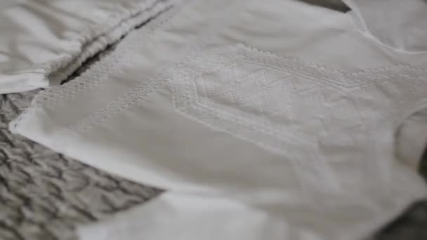 Gros plan sur les vêtements de bébé pour un nouveau-né sur un fond de lit