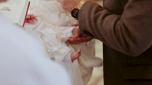 Der Priester liest das Gebet in der Kirche. Der Taufritus in der orthodoxen Kirche. Firmung eines Babys, der Priester macht ein Ritual der Salbung mit Öl während der Säuglingstaufe — Stockvideo