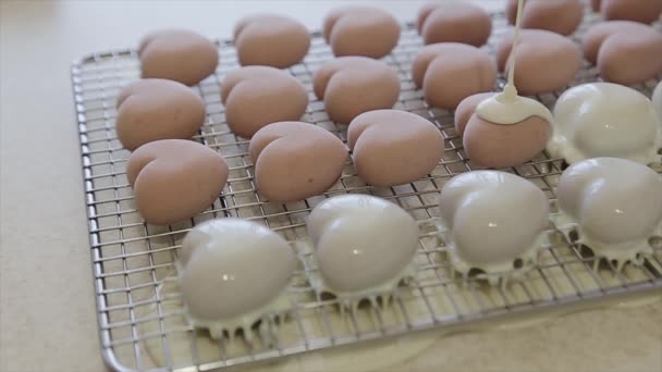 Gros plan d'un glaçage coulant sur des desserts en forme de cœur. Confiserie professionnelle pour la Saint Valentin — Video