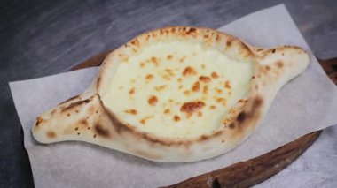 Doğulu mutfağın hazırlanma süreci. Gürcü yemeği. Adjarian Khachapuri yapımı. Şef az önce pişmiş khachapuri 'ye yumurta sarısı ekliyor.