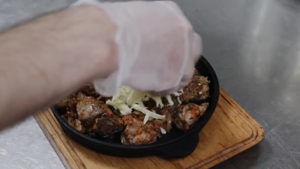 Chef adicionando queijo durante a preparação prato chashushuli da cozinha georgiana. Refeição georgiana picante com carne de vaca — Vídeo de Stock