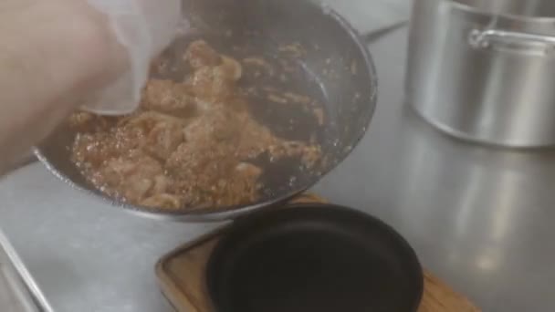 Шеф-повар приносит только что приготовленные чашули и кладет блюдо в железную тарелку. Грузинское блюдо из мяса в ресторане. Грузинская кухня — стоковое видео