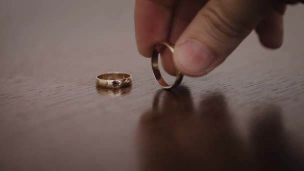 Anillos de boda giratorios. Anillos giratorios de novio y novia sobre la mesa. Primer plano de los anillos de boda giratorios — Vídeos de Stock