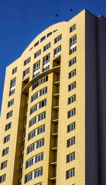 Mavi gökyüzünün altında çok katlı bir bina.