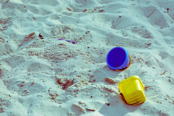 Güneşli kumsalda birkaç çocuk oyuncağı