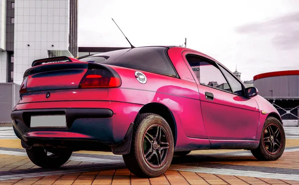 Zuur roze karmozijnrode sportwagen in achteraanzicht — Stockfoto
