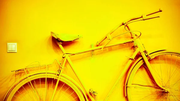 장식용 주택 벽에 붙어 있는 오래 된 노란 자전거 — 스톡 사진