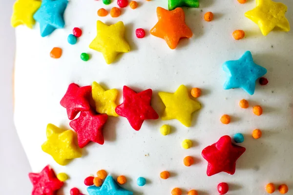 Bir sürü renkli şeker yıldızlı beyaz pasta.