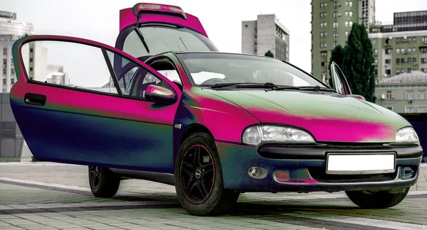 Şehir manzarasına karşı eski kırmızı metalik spor araba coupe