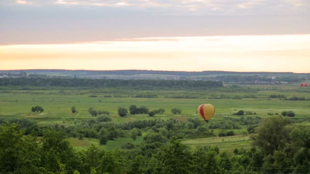 Le ballon se prépare à décoller au coucher du soleil. Casovom d'air sur un champ vert — Video