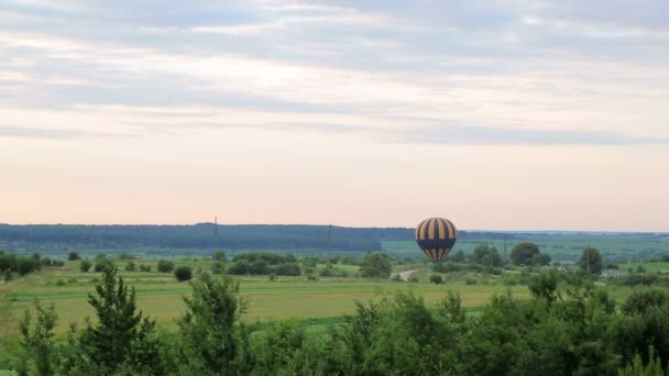 Balon przygotowuje się do startu o zachodzie słońca. Casovom powietrza na zielone pola — Wideo stockowe