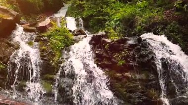 Ağır çekim bir küçük dağ şelale. 240 fps. dağ dere taşları bir alt düşüyor.