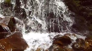 Ağır çekim bir küçük dağ şelale. 240 fps. dağ dere taşları bir alt düşüyor.