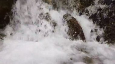 Ağır çekim bir küçük dağ şelale. Dağ dere taşları bir alt düşüyor.