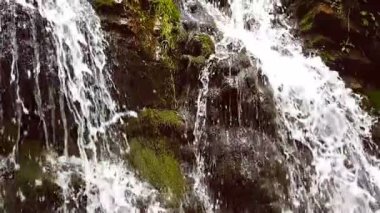 Ağır çekim bir küçük dağ şelale. 240 fps. dağ dere taşları bir alt düşüyor.
