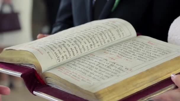 Priester draait de Bijbel pagina op een close-up in de kerk tijdens de ceremonie — Stockvideo