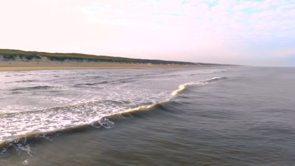 Hullám a partra, a háttérben, a háztáji nap felé halad. Zanvoort Hollandia — Stock videók