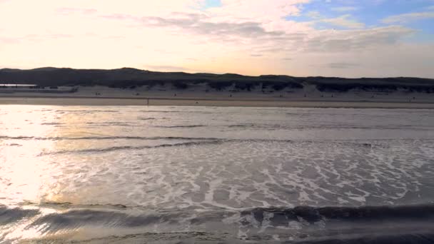 Vlna se pohybuje směrem k břehu v pozadí slunce dvorku. Zanvoort Nizozemsko — Stock video
