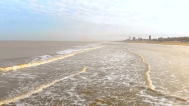 Havadan görünümü. Yavaş hareket uçuş kıyıya güneşli sabah deniz ve gelen dalgalar üzerinde. Hollanda Zandvoort. Kuzey Denizi. Sahil hattı