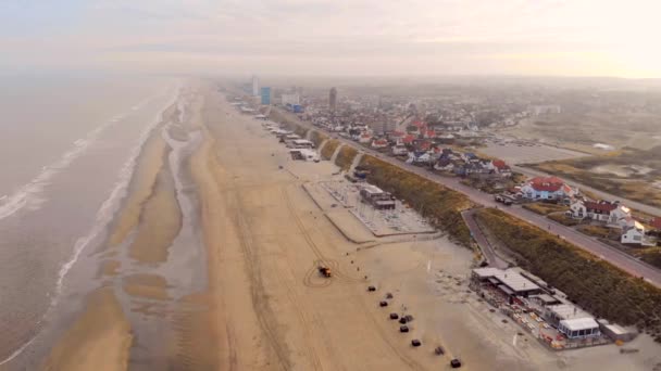 Quadcopter flight over the Zandvoort beach in the Netherlands. Morning sunrise over the city — Stock Video