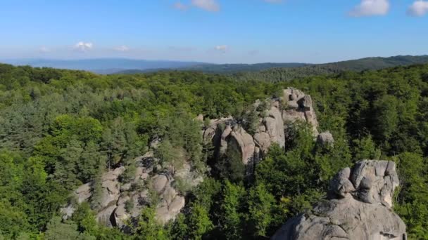 Aéreo. Grande relevo de rochas entre a densa floresta verde nas montanhas — Vídeo de Stock