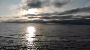 deniz güneşli bir günde sinek. Güneş batıda suya yansıyan