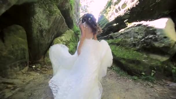 웨딩 드레스에 귀여운 신부 바위, 사이 실행 하 고 멋진 미소를 카메라에서 보이는. 행복 한 얼굴, 감정 — 비디오