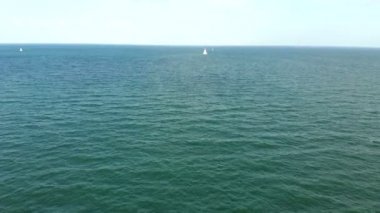 Tekne ile denizde yüzen bir beyaz yelken.