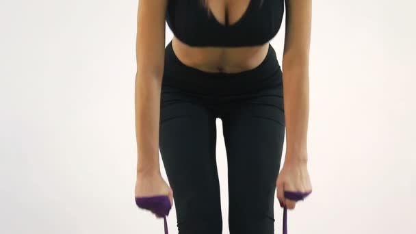 Mujer sosteniendo un torniquete en sus manos realiza ejercicios deportivos en el gimnasio . — Vídeo de stock