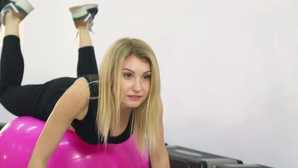 Söt flicka utför fitnessövningar på bollen. Hälsosam livsstil i gymmet — Stockvideo