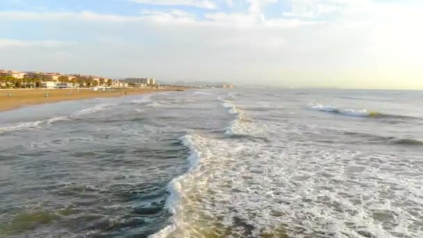 Lage vlucht over de golven komen naar de wal. De Golf in de schaduw vormt een grote hoeveelheid schuim en bubbels. Luchtfoto Spanje, de Middellandse Zee — Stockvideo