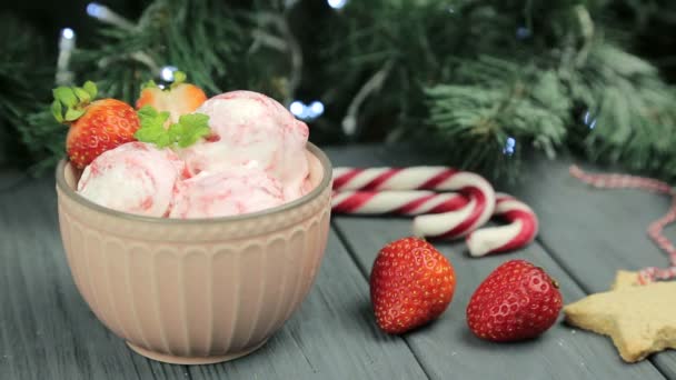 Мороженое на новый год. Красивая композиция мороженого и клубники на фоне рождественской елки — стоковое видео