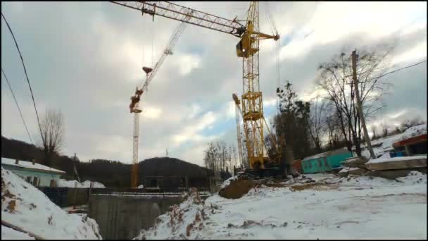 Timelaps de la construcción de invierno. Trabajos de grúas en construcción. Nubes en movimiento rápido — Vídeo de stock