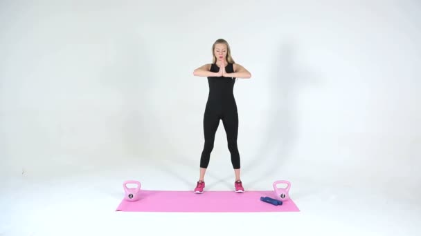 Het meisje geeft yoga oefeningen op een witte achtergrond — Stockvideo