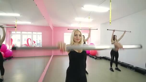 Fyra vackra flickor, är engagerade i sport, fitness lyft baren i gymmet. Sport liv och en hälsosam livsstil — Stockvideo