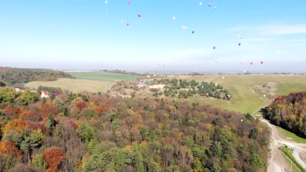 Coloridos globos de helio vuelan al cielo. Vista aérea . — Vídeo de stock