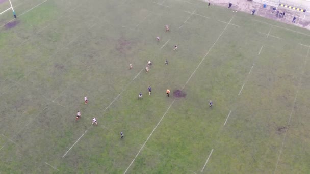 Vista aérea de pessoas jogando um jogo de rugby em um campo verde na Ucrânia. Dia nebuloso sem sol — Vídeo de Stock