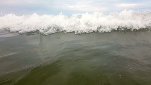 SLOW MOTION, CLOSE UP The wave moves towards the shore, moving towards the beach. Капли волны пульсируют в гору. Медленное движение морской волны у берега — стоковое видео