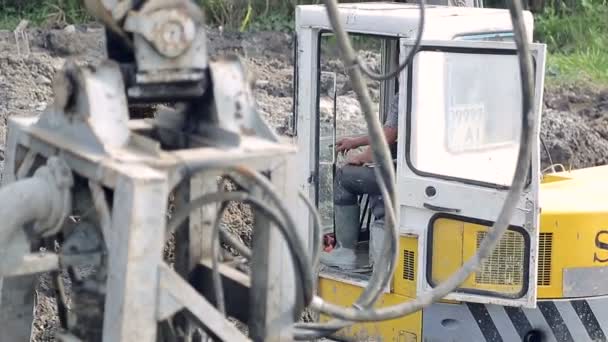 An employee manages an excavator. Raises the ladle and prepares for work — Stock Video