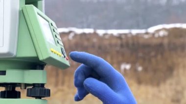Yakın çekim parmak mesafe ölçme iş yerinde Surveyor düğmeleri iter. Kış inşaat kavramı