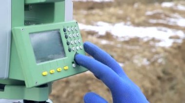 Yakın çekim parmak mesafe ölçme iş yerinde Surveyor düğmeleri iter. Kış inşaat kavramı